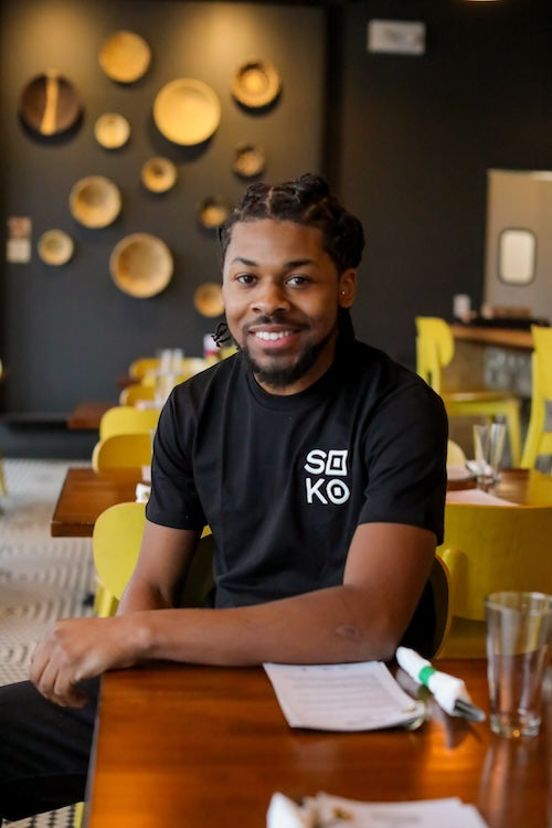 Man wearing black t-shirt with white embroidered Soko logo